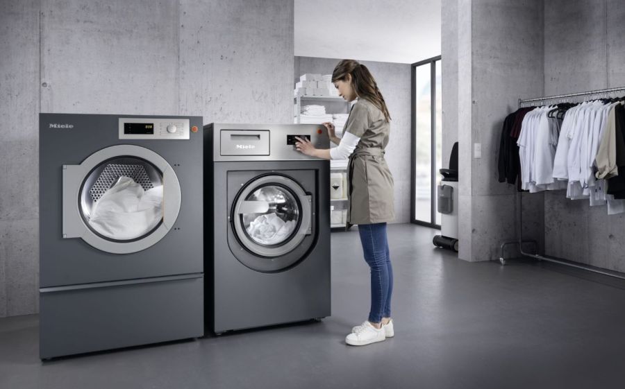 Frau schaltet Großwaschmaschinen ein