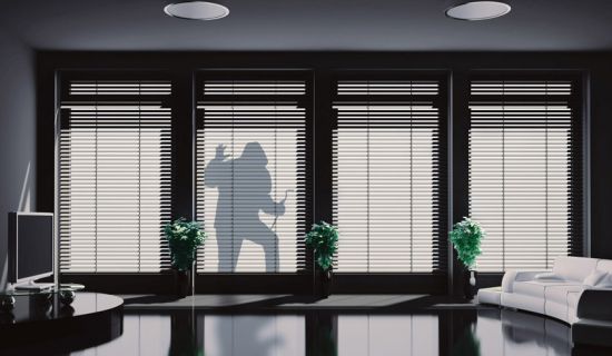 Silhouette eines Einbrechers vor den Terrassenfenstern