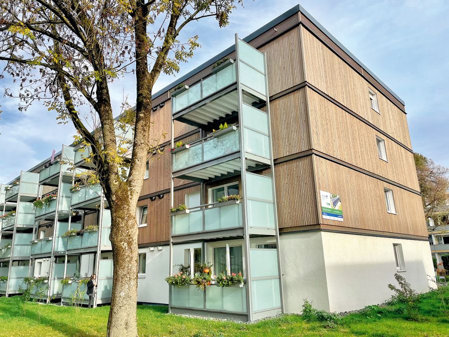 Sanierter Bochumer Wohnkomplex: Mehrfamilienhaus mit Balkonen und Holzfassade