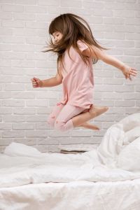 Kind hüpft auf dem Bett