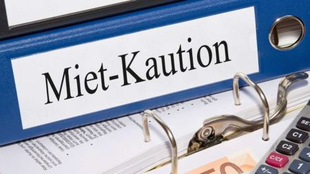 Ein blauer Ordner mit der Aufschrift "Miet-Kaution" liegt geöffnet auf einem Schreibtisch.