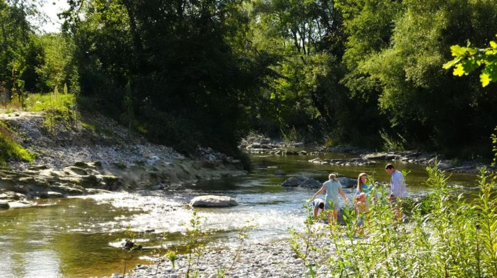 Kinder spielen am naturnahen Fluss