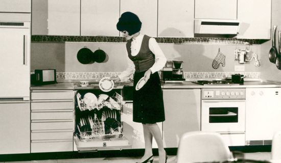 Frau räumt Geschirrspüler ein
