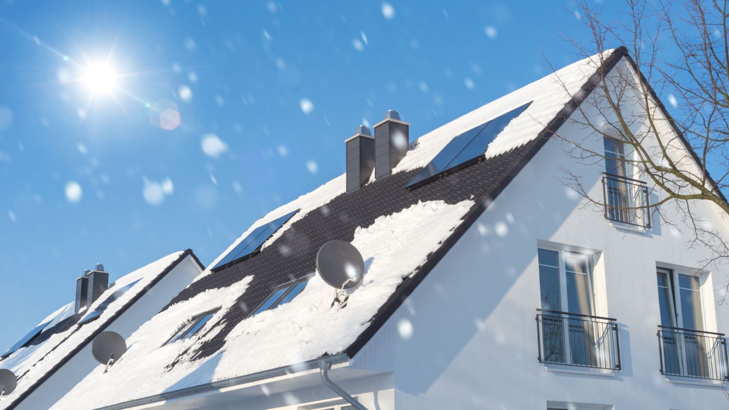 Schnee fällt auf Hausdach mit PV-Anlage
